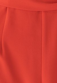 Punane kangas, millel on sile tekstuur ja kerge läike. Omab peeneid voldikesi ja struktureeritud kujundust. Ilma nähtavate mustrite või armsuseelementideta.