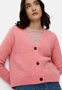 Różowy dziergany kardigan z dekoltem w serek, długimi rękawami i czterema ciemnymi guzikami. Charakteryzuje się teksturowanym wykończeniem i krótkim dołem.