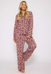 Bordeaux pyjama-set met een roze abstract luipaardprint, lange mouwen, knoopsluiting aan de bovenkant en relaxte pasvorm broek. Glad materiaal zonder zichtbare hardware.