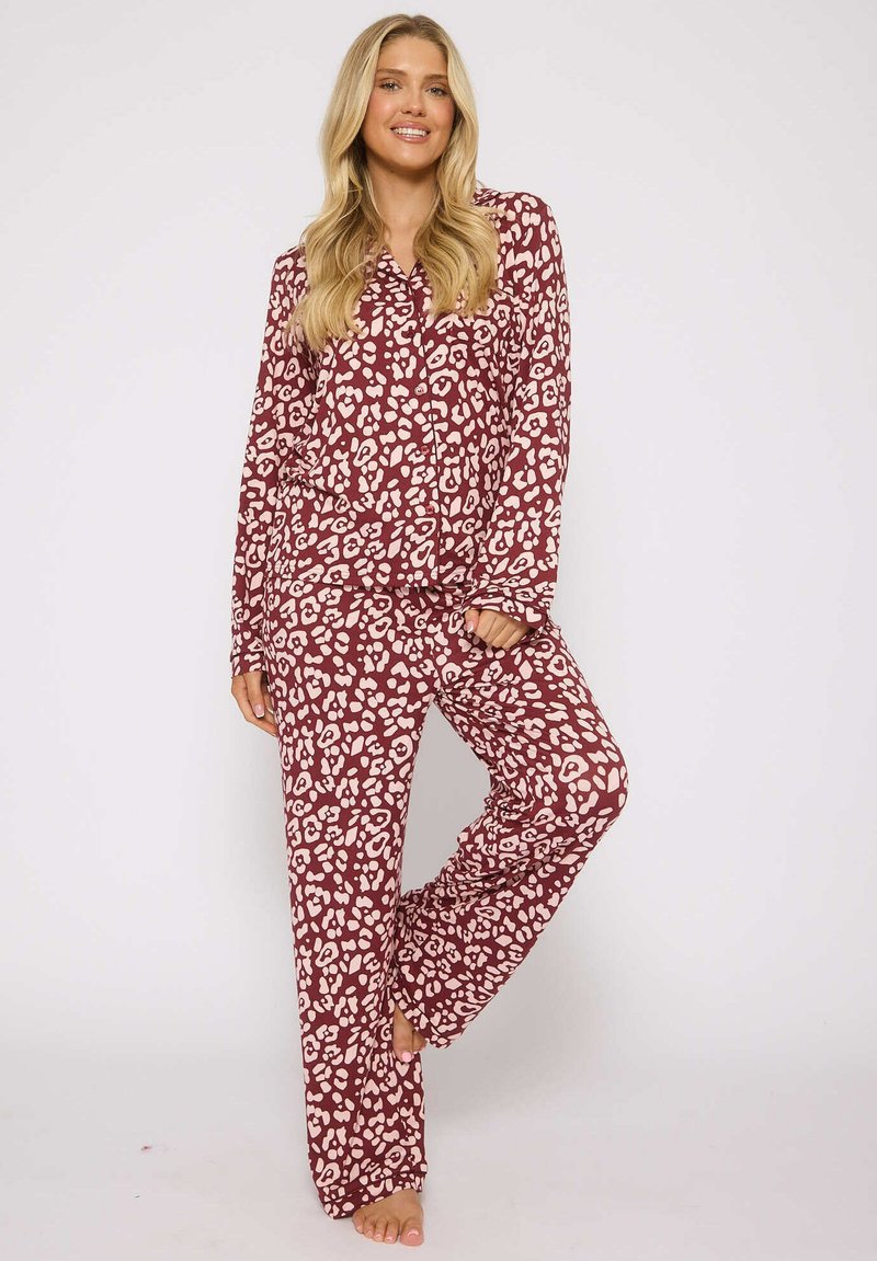 Bordeaux pyjama-set met een roze abstract luipaardprint, lange mouwen, knoopsluiting aan de bovenkant en relaxte pasvorm broek. Glad materiaal zonder zichtbare hardware.