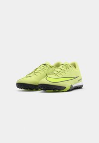Par svijetlozelenih Nike Air Zoom sportskih cipela s crnim i bijelim potplatima na bijeloj pozadini.