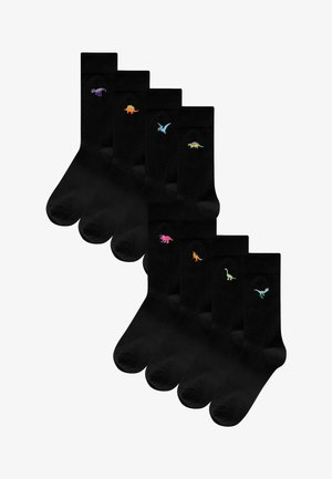 Calzini neri con ricami di dinosauri colorati sul risvolto, che mostrano design tra cui un T-Rex, un triceratopo e un pterosauro.