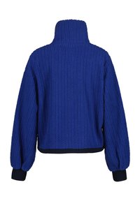 Veste tricotée bleue avec un col haut, des manches volumineuses et des poignets côtelés bleu foncé. Tissu texturé avec des rayures horizontales sur toute la surface.