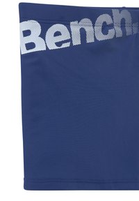 Marineblaue Sportshorts mit glatter Textur und einem weißen gepunkteten Logo entlang des Bundes. Genähter Saum und elastischer Bund für zusätzlichen Komfort.