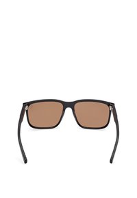 Okulary przeciwsłoneczne z czarną plastikową oprawką, brązowymi soczewkami i zaokrąglonym kwadratowym kształtem. Posiadają metalowe akcenty na zawiasach. Lekka konstrukcja.