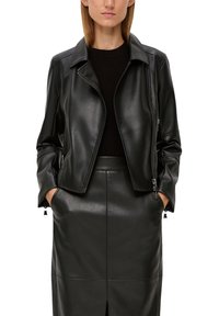 Veste en cuir noir avec fermeture éclair, col en notch et poches zippées, accompagnée d'une jupe crayon assortie. Texture lisse, coupe ajustée.