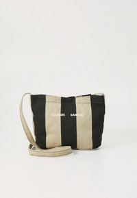 Mała torba na ramię z szerokimi pionowymi czarno-beżowymi pasami oraz regulowanym beżowym paskiem, z białym napisem marki z przodu.