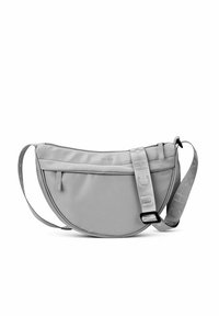 Šedá textilní taška přes rameno s zakřiveným tvarem, obsahující přední kapsu na zip, nastavitelný popruh a detaily loga na popruhu.