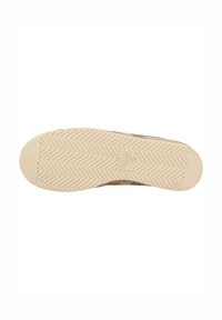 Sneaker beige con una suola leggera testurizzata caratterizzata da un motivo a zigzag. La parte superiore presenta linee di design sottili e dettagli di branding.