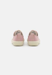 Chaussures slip-on en toile rose avec une silhouette basse, un arrière renforcé et une semelle en caoutchouc. Texture douce avec un détail de couture au niveau du talon.