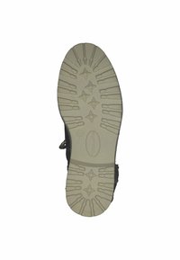 Botín negro con una suela de goma texturizada. La suela presenta un patrón de estrellas y múltiples ranuras para tracción. Talla 37 indicada en el lateral.