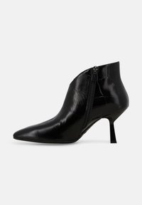 Stivaletto alla caviglia in vernice nera con punta appuntita, cerniera laterale e tacco sottile di altezza media su sfondo bianco.