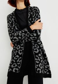 Cardigan de leopardo negro y gris; textura suave; frente abierto; puños acanalados; diseño de longitud media; corte relajado.