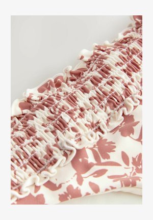 Blumendruckstoff in Creme und stumpfem Rosé, mit geraffter Textur und geschwungenen Kanten, die zarte Details und weiches Material hervorheben.