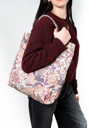 Borsa a spalla floreale in rosa, crema e viola con tessuto testurizzato, caratterizzata da un motivo di fiori e manici in morbida pelle.