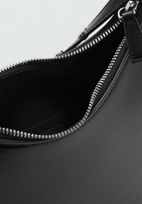 Czarna skórzana torebka na zamek błyskawiczny, z srebrnymi akcentami, o gładkiej fakturze i prostym, zorganizowanym wzornictwie.