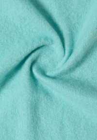 Turkusowy materiał o miękkiej, puszystej fakturze, z spiralnym zagięciem, ukazujący swój lekki i elastyczny design.