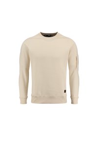 Sudadera color beige claro con puños y bajo acanalados, que presenta un bolsillo con cremallera en la manga y un pequeño parche de logo marrón en el lado.