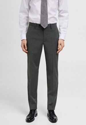 Gray dress pants with a textured finish, tailored fit, and pressed creases. Worn with a white shirt and patterned tie. Black leather shoes.