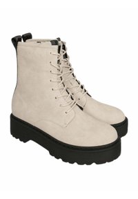 Stivaletti alla caviglia in suede beige con suola in gomma nera spessa, design con lacci e linguette nere a contrasto sul retro.