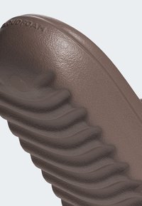 Brown molded foam sandal with textured surface and wave-like ridges, featuring "CLOUDFOAM" branding along the side.