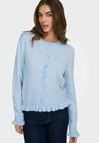 Ljusblå stickad cardigan med rund hals, volangdetaljer i nederkant och ärmslut, prydd med fem knappar fram. Mjuk, strukturerad tyg.