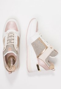 Höga sneakers i vitt, rosa och guld. Har strukturerade tygpaneler på sidorna, metalliska detaljer och en kraftig sula.