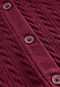 Bordo pleteni kardigan s kabelskim vzorcem in osrednjim gumbnim zapenjalom; ima okrogle gumbe z embosiranimi logotipnimi podrobnostmi.