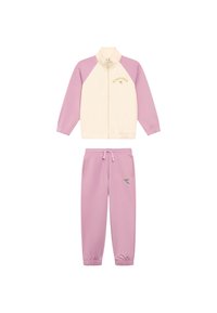 Giacca rosa con zip, corpo crema e maniche rosa, con un logo giallo. Pantaloni joggers rosa abbinati con un logo in accentuazione sulla coscia.