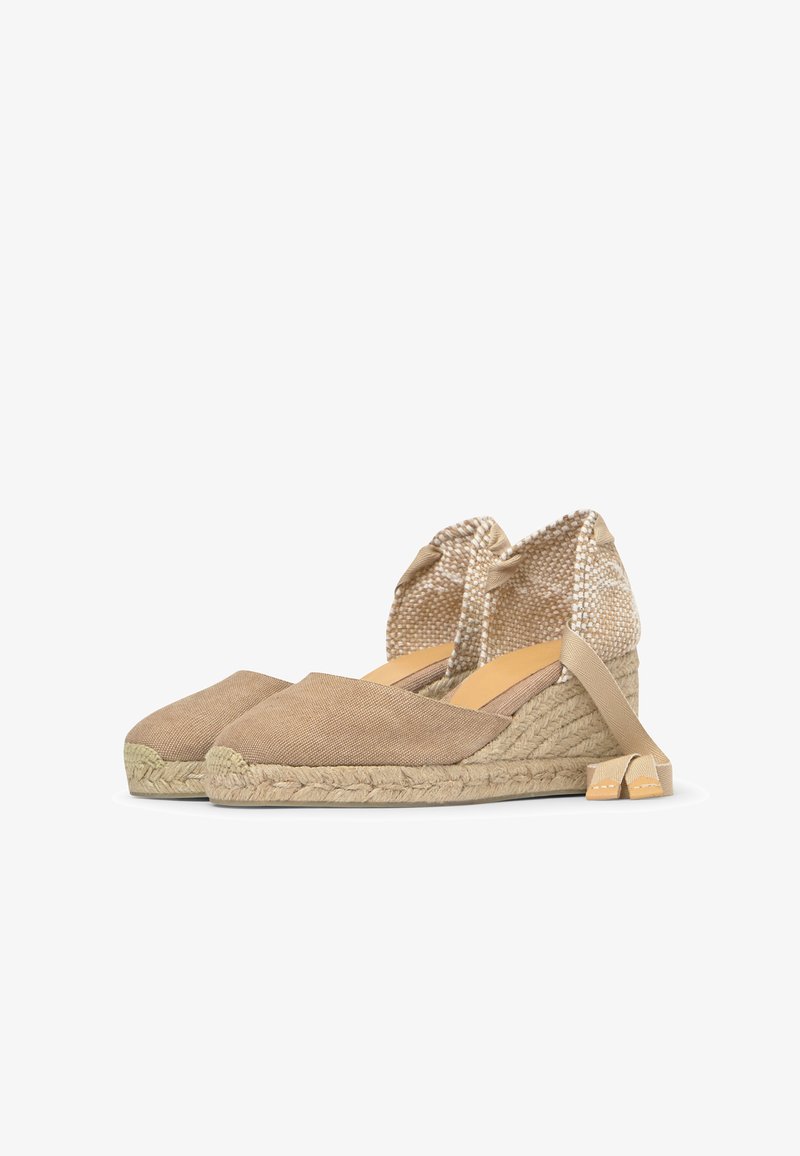Beige canvas espadrilles med kilehæl, flettede reimsåler og ankelbånd, vist i profil på hvit bakgrunn.