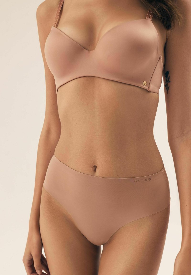 Light pink seamless bra with a smooth finish, layered design, and adjustable straps. Matching high-waisted seamless underwear in similar color.
