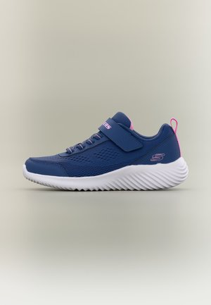 Scarpa sportiva blu navy con suola bianca, dettagli rosa, lacci elastici e cinturino in velcro su sfondo neutro.