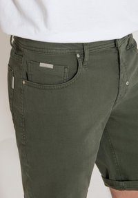 Groene katoen short met een slim fit, voorzien van een knoop- en ritssluiting, riemlussen en accenten van zilver hardware.
