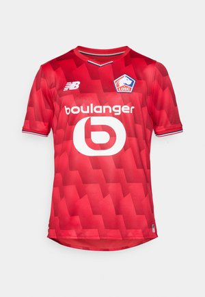 Maillot de football rouge avec un motif géométrique, col rond, manches courtes. Présente un logo blanc prominent au centre et un logo de marque sur l'épaule.