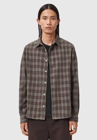 Kariertes Flanellhemd in dunklen Braun-, Grau- und Rottönen. Klassischer Kragen, durchgehende Knopfleiste und lange Ärmel mit Knopfmanschetten.