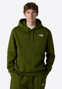Olijfgroene hoodie met een kangoeroezak en verstelbare koordjes. Voorzien van een wit logo op de linker borst en ribgebreide boorden.