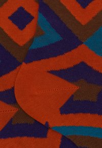 Calzini colorati con un motivo geometrico nei toni dell'arancione, marrone, viola e turchese. Realizzati in morbido tessuto di maglia con una texture liscia.