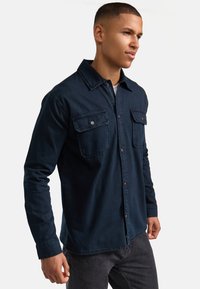 Dunkelblaues Hemd mit Knopfleiste aus leichtem Stoff. Verfügt über zwei Brusttaschen, einen Kragen und lange Ärmel. Strukturiertes, lässiges Design.
