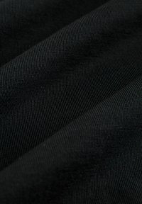 Must mustrakk, millel on sooneline tekstuur, näidates kokku volditud kihte, mis rõhutavad selle venivust ja elastset omadust. Sile, ühtlane pind.