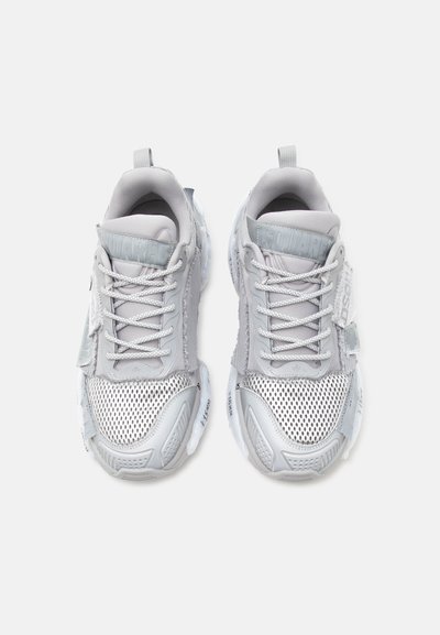 Ζευγάρι αθλητικά παπούτσια ανοιχτό γκρι με δίχτυ στην περιοχή των δακτύλων, χοντρές λευκές σόλες και κορδόνια, σε θέα από πάνω σε λευκό φόντο.