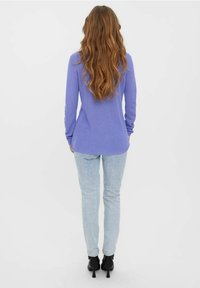 Violetti pitkähihainen neulepusero, jossa on ribbineulostekstuuri, suora leikkaus, yhdistetty vaaleansinisiin kapeisiin farkkuihin ja mustiin korkokenkiin. Minimalistinen muotoilu, ilman kuvioita.