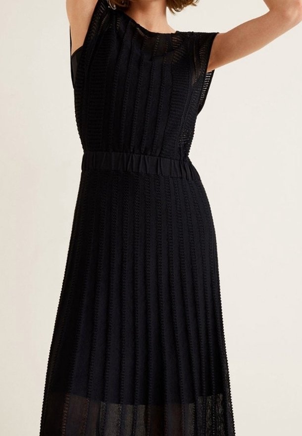 Robe noire sans manches présentant un design texturé plissé avec une taille cintrée et une partie inférieure semi-transparente.