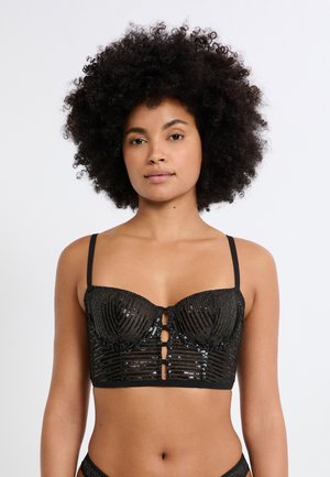 Bralette negro con textura de lentejuelas, copas estructuradas y líneas verticales. Cuenta con tirantes ajustables y cierre frontal con tres botones.