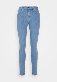 Jeans ajustados en denim azul claro, con una cintura de altura media, cinco bolsillos y un ligero desgastado en los muslos para un efecto de usado.