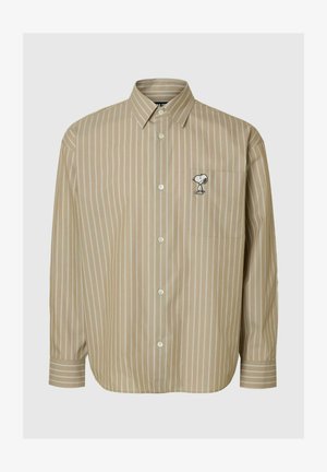 Camisa beige de rayas con botones y un bolsillo. Presenta un gráfico de Snoopy en el pecho, confeccionada con una tela suave y un ajuste relajado.