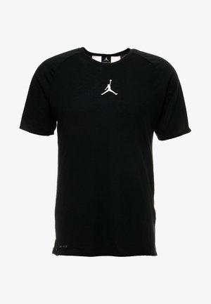 Černé krátké sportovní tričko s bílým logem Jumpman uprostřed na hrudi a malým nápisem „Dri-FIT“ blízko spodního lemu.