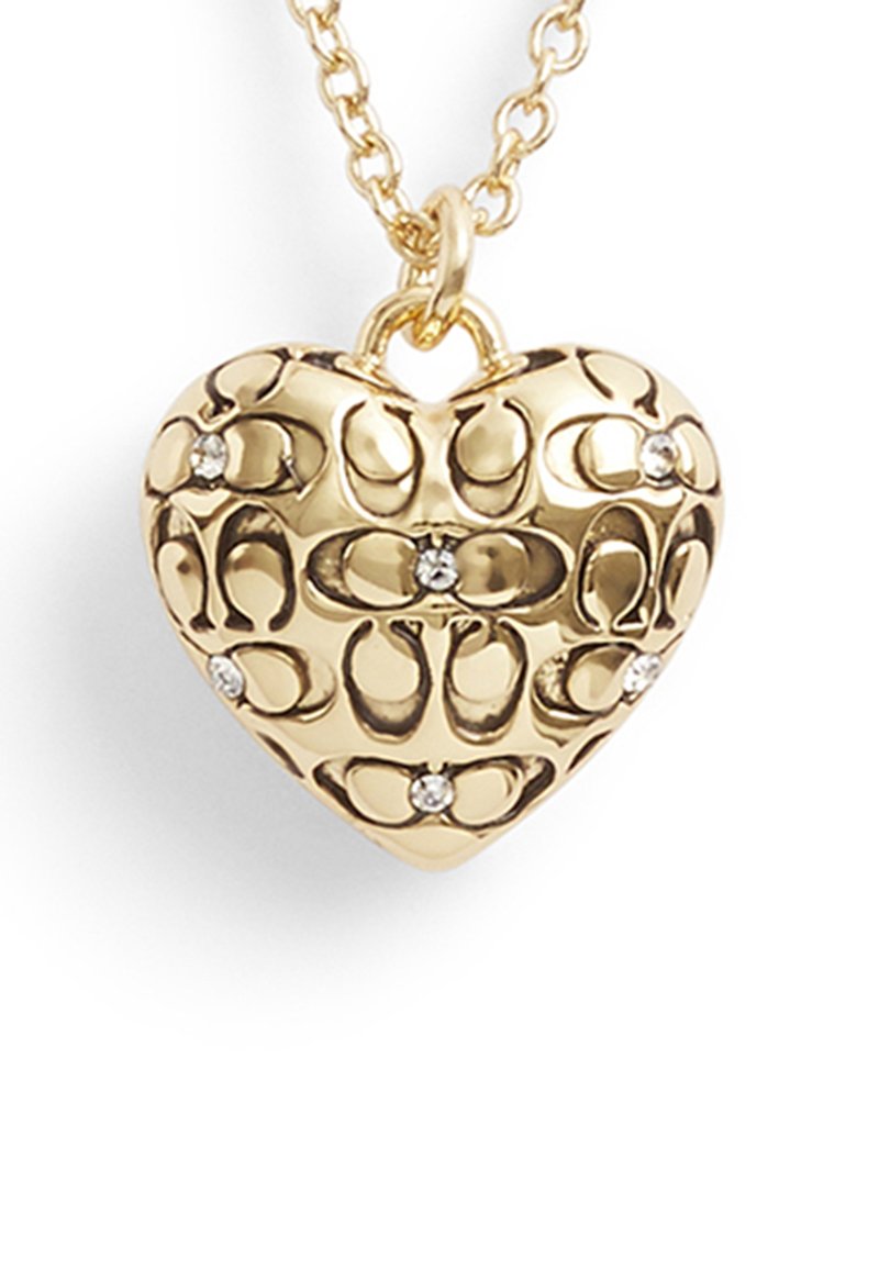 Collana con pendente a forma di cuore in oro con un intricato motivo a intaglio e piccoli accenti in pietra trasparente. Presenta una catena in oro per indossarla.