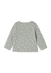 Langarmshirt aus leichtem grünen Baumwollstoff mit weißem Blumenmuster, Rundhalsausschnitt und geradem Saum. Die Textur ist glatt.