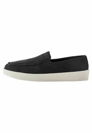 Zwarte suède slip-on loafer met witte rubberen zool, met gestikte details langs de bovenkant en zijkanten.