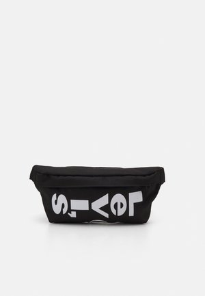 Schwarze Stoff-Gürteltasche mit fett gedruckten weißen Buchstaben, die vorne teilweise "Levis" buchstabieren, vor schlichtem weißen Hintergrund.
